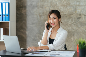 Portrait of happy lady typing in mobile while locating at desk in office, Young business woman on the phone at office.