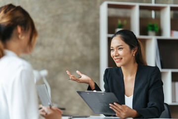 Team work process. Two asian women with laptop in open space office. Business concept.