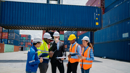 Group of engineer worker and manager standing in the shipping yard container.