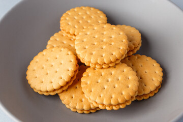 Minimalism. Cookies with fruit filling on a gray background in a gray plate. Light background. Close-up in the center. Side view. A place to copy.