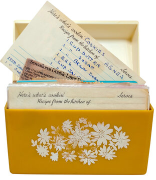 Old, yellow 1960s recipe box with handwritten recipes on index cards.