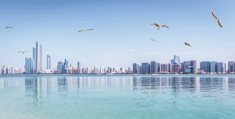 Fotobehang Abu Dhabi Panoramisch uitzicht op Abu Dhabi Skyline VAE met wolkenkrabbers en zee met meeuwen