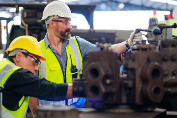 caucasian or hispanic latin man worker wearing safety goggles control lathe machine to drill...