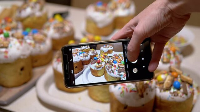 Female Hands Taking Pictures on Smartphone of Easter Cakes on the Table. Translation: video clip, video, photo, portrait, square. Blogger blogging about food, Easter. Orthodox religion event. 4K.