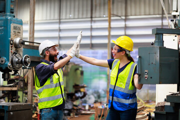 Unity and teamwork concept. team standing hands together. Professional mechanical engineering male operate lathe machine with apprentice female at metal factory workshop.