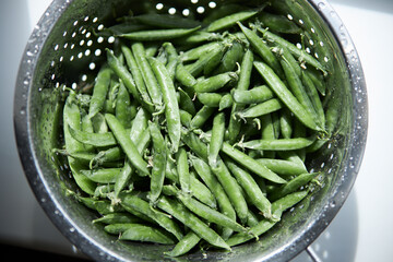 Young peas in pods in an iron colander. Diet. healthy eating 