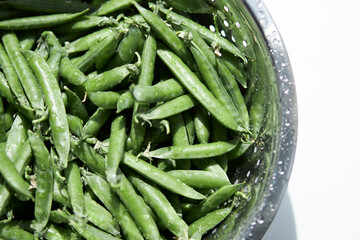 Young peas in pods in an iron colander. Diet. healthy eating 