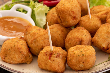 gros plan  d'accras de morue et sauce dans une assiette	