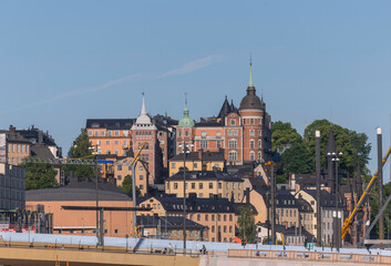 Fototapeta premium Old 1700s houses in the block Bastugatan and the new bridge Guldbron in the district Södermalm a summer day in Stockholm
