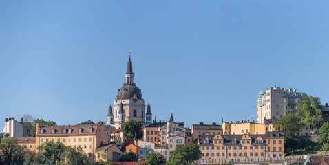 The church Katarina with old yellow 1700s houses on the water front ridge of the district Södermalm an summer day in Stockholm