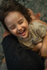 dad plays with his son, father spends time with his children, they have fun, fool around and run, the relationship between father and child. The concept of a happy family