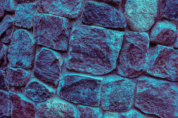 Stone wall in blue neon color, stony texture