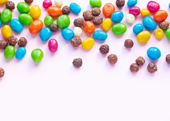 Fototapeta na wymiar Colorful chocolate and jellybeans candy background top view