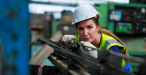 caucasian female engineering worker wearing safety hardhat helmet inspecting auto robot lathe...