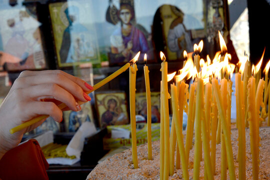 Woman lighting an ortohodx church candle