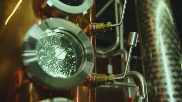 Hot water , liquid boiling inside distillery or filtration tank . Alcohol drink factory or physical experiment laboratory . Cooper or metal machine . Hot temperature , high pressure . Close up
