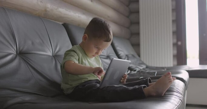 Modern child looking at the touchpad at home