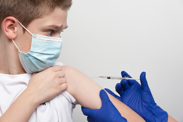 Medical and vaccination topic. Hands of nurse with syringe making vaccine injection to caucasian...