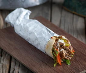lebanese chicken shawarma served in a dish side view on wooden table background - obrazy, fototapety, plakaty