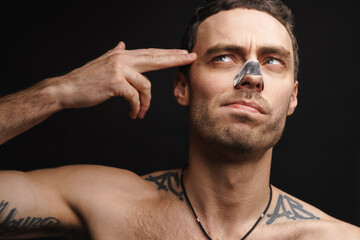 Mid aged white shirtless man using cleansing strip