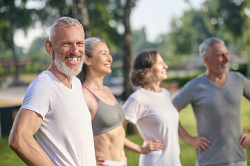 A group of mature people in sportswear feeling great together in the park
