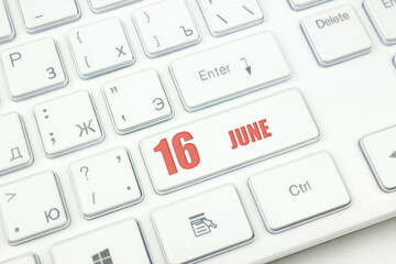 June 16th. Day 16 of month, Calendar date. Cropped view of Modern White Computer Keyboard with calendar date. Concept workspace, freelance, deadline.  Summer month, day of the year concept.