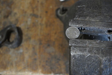 Coin one Russian ruble clamped by a black metal vice. Russia economy under global sanctions