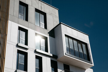 Modern apartment buildings Facade with a blue sky. Glass surface with sunlight.