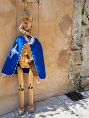 Wooden marionette with a blue cape