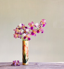 irises in  beautiful glass vase against  green wall