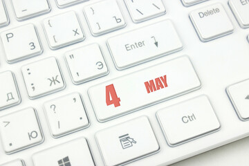 May 4th. Day 4 of month, Calendar date. Cropped view of Modern White Computer Keyboard with calendar date. Concept workspace, freelance, deadline.  Spring month, day of the year concept.