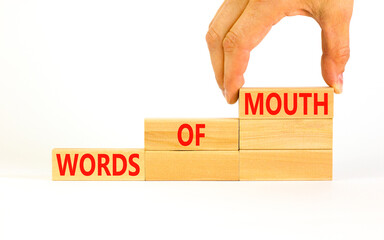 Words of mouth symbol. Concept words Words of mouth on wooden blocks on a beautiful white table white background. Businessman hand. Business, finacial and words of mouth concept. Copy space.