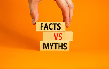 Facts vs myths symbol. Concept words Facts vs myths on wooden blocks on a beautiful orange table orange background. Businessman hand. Business, finacial and facts vs myths concept. Copy space.