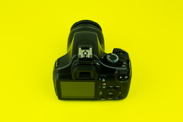 Camara fotográfica Reflex DSLR en fondo amarillo. Concepto de tecnología