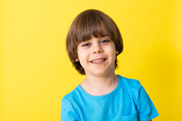 handsome little boy in blue shirt, yellow background, banner, space for text