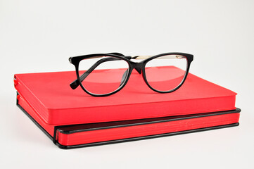 Black Eyeglasses and notepads on white background.