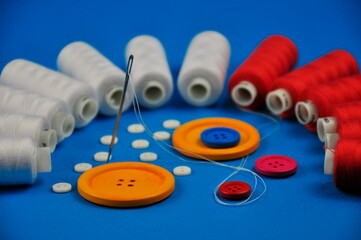 Sewing thread spools and multicolored buttons.