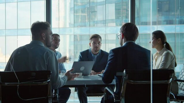 Discussion of work issues at a meeting in office: young businessmen working