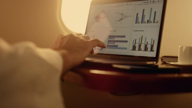 Hands working digital computer closeup. Manager checking company graphs on plane