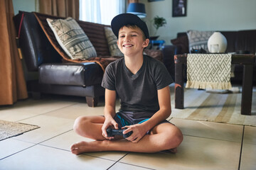 I love this game. Full length portrait of a young boy playing video games at home. © Tamani Chithambo/peopleimages.com