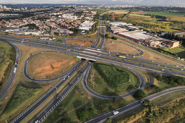 Vista aérea da rodovia Dom Pedro em Campinas, São Paulo. Imagem com carros, rodovia e intersecção. 