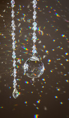 Selective focus on ball and teardrop shape crystal rainbow maker suncatcher hanging in home. Good...