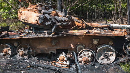 The war in Ukraine, a destroyed tank with a torn tower stands in a forest near the road, close-up view, Severodonetsk,  Luhansk Oblast, Ukraine