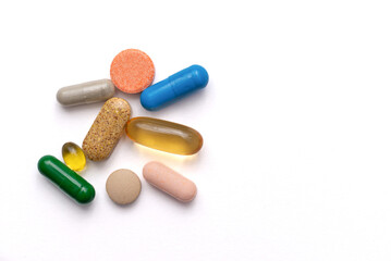 colored pills and vitamins on a white background with copyspace