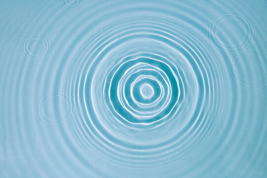 Blue water texture, surface with rings and ripples. Spa concept background. Flat lay, copy space.