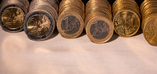 Lined up one euro, two euro and fifty cent coins. European currency.