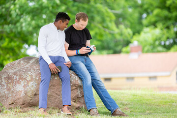 Fototapeta premium Two guys reading the Bible in the park