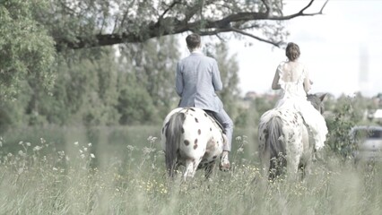 Happy bride and groom on horseback in the forest, true love, beautiful nature
