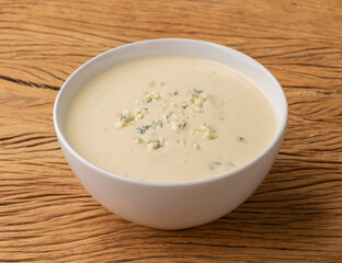 Cheese soup in a bowl over wooden table