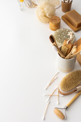 Wooden toothbrushes with natural bristles in a ceramic glass, face and skin care products, bath accessories, spa and beauty concept